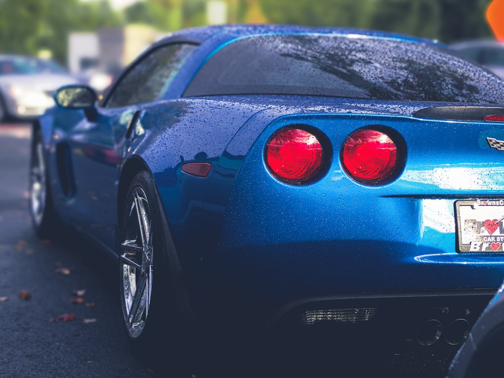 selective focus photography of parked blue Chevrolet Corvette coupe