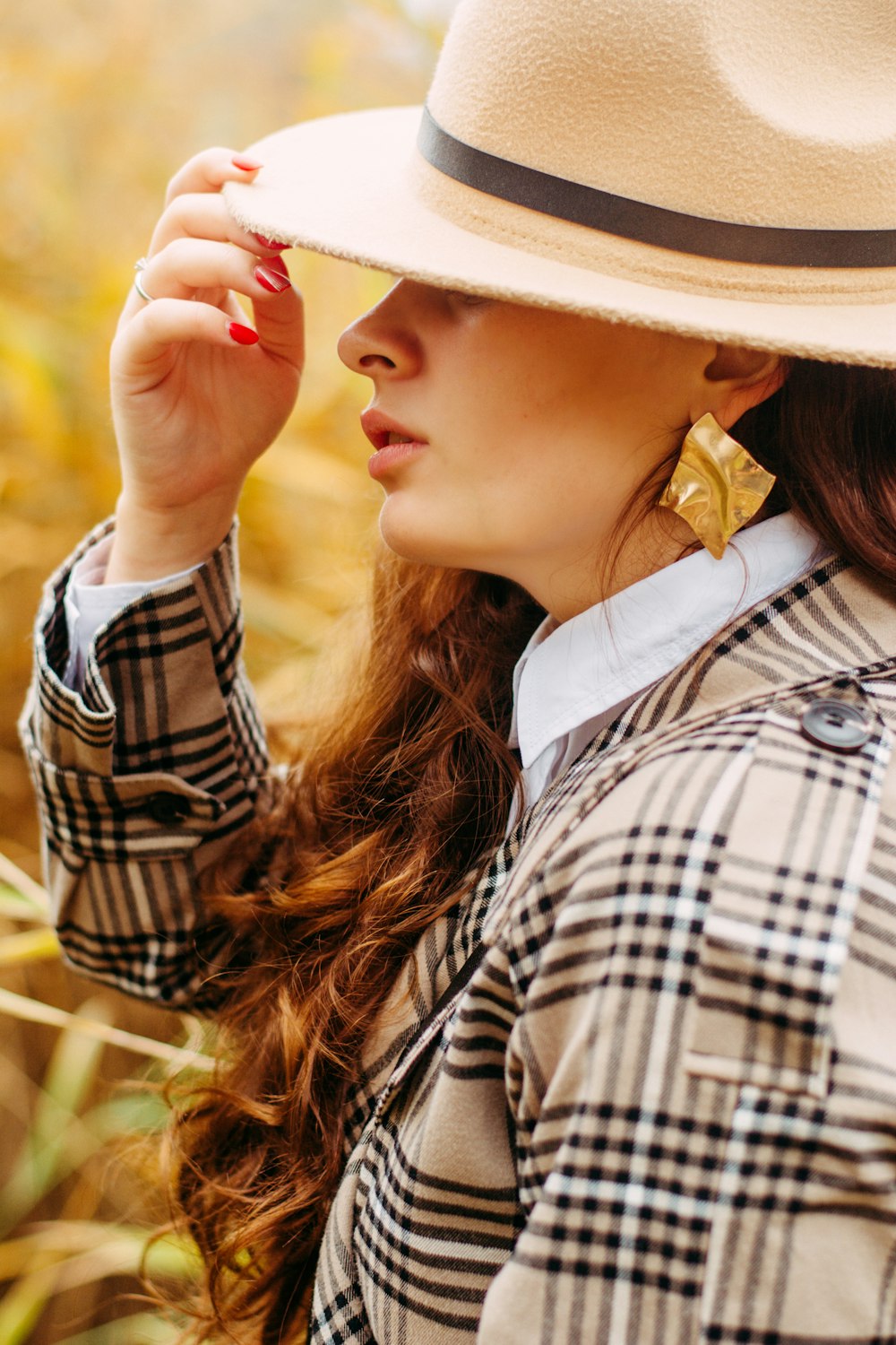 woman wearing black, white, and brown Burberry coat touching her cowboy hat  photo – Free Brown Image on Unsplash