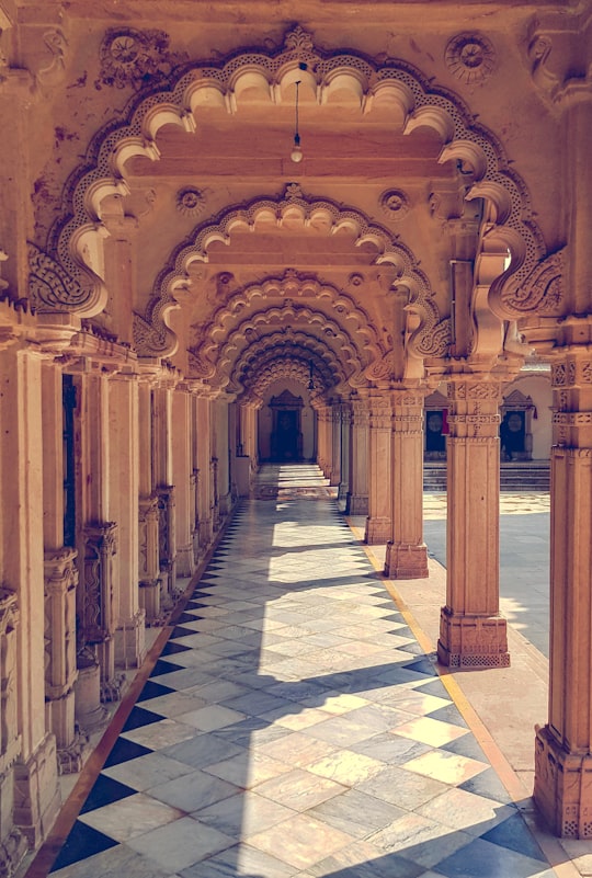 brown concrete hallway in Hutheesing Jain Temple India