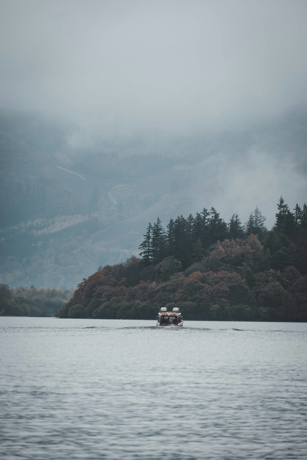 gray sailing boat near land during daytime