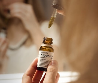 selective focus photography of person holding C1000 bottle