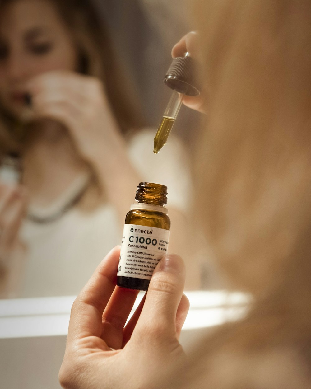 selective focus photography of person holding C1000 bottle