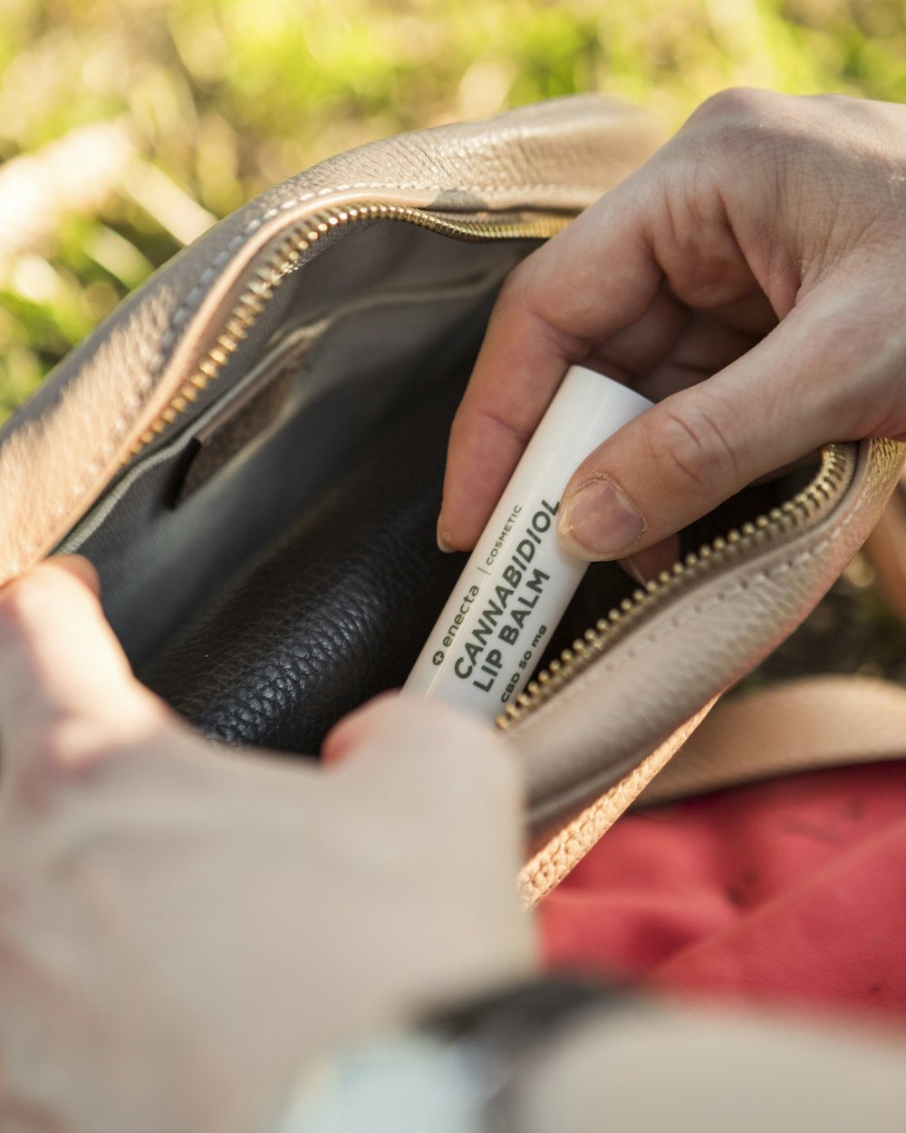 person talking Cannabidiol lip balm from bag