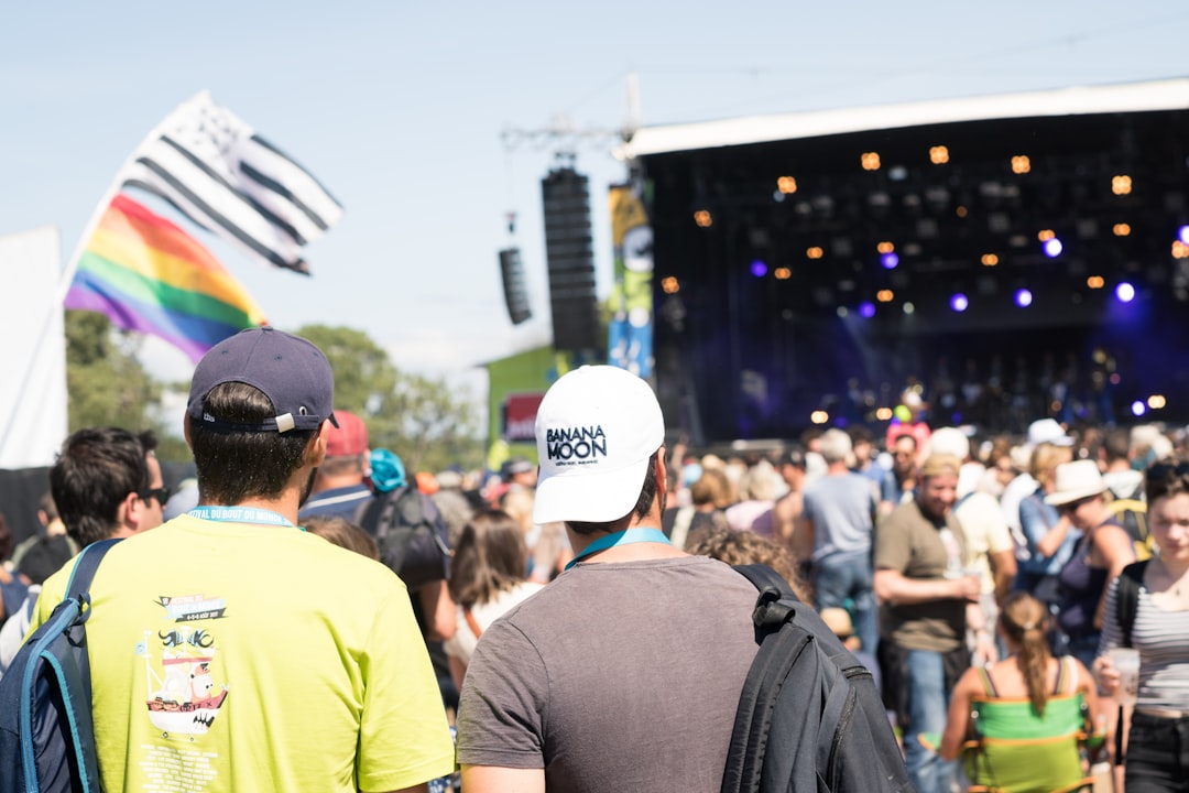 people standing near stage, Two men standing in a festival
