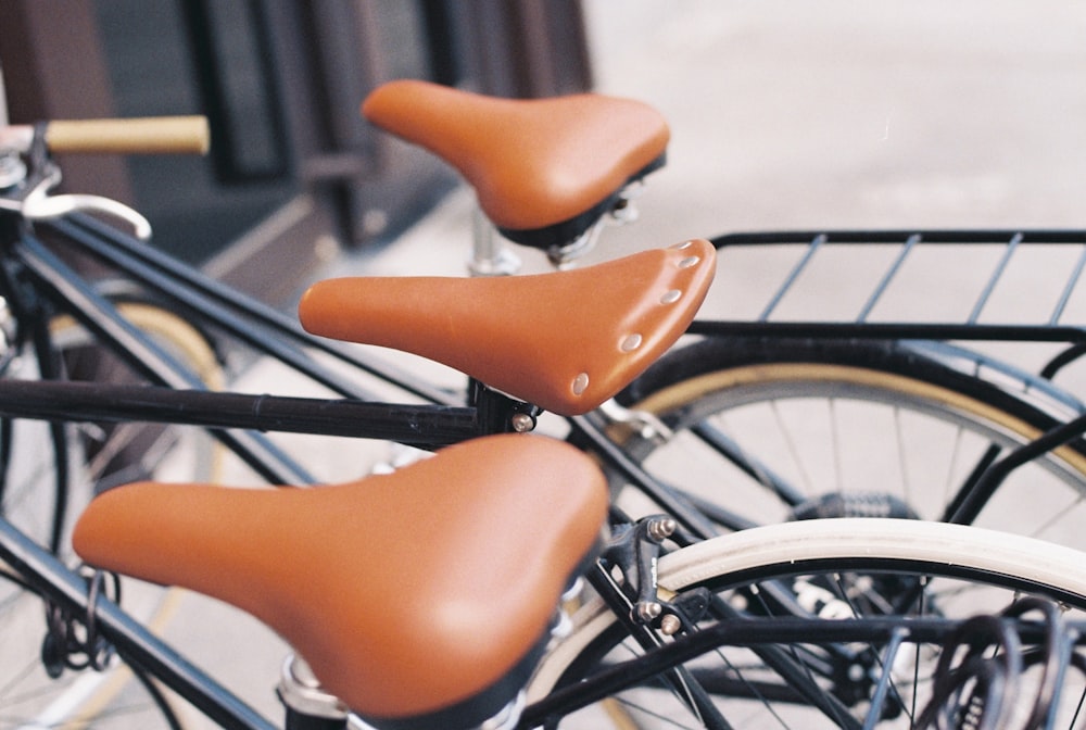 three black commuters bikes parked beside wall