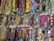 A display of various colorful, patterned fabrics arranged neatly in rows. The fabrics showcase an array of intricate designs, vibrant colors, and textures, creating a visually stimulating scene.