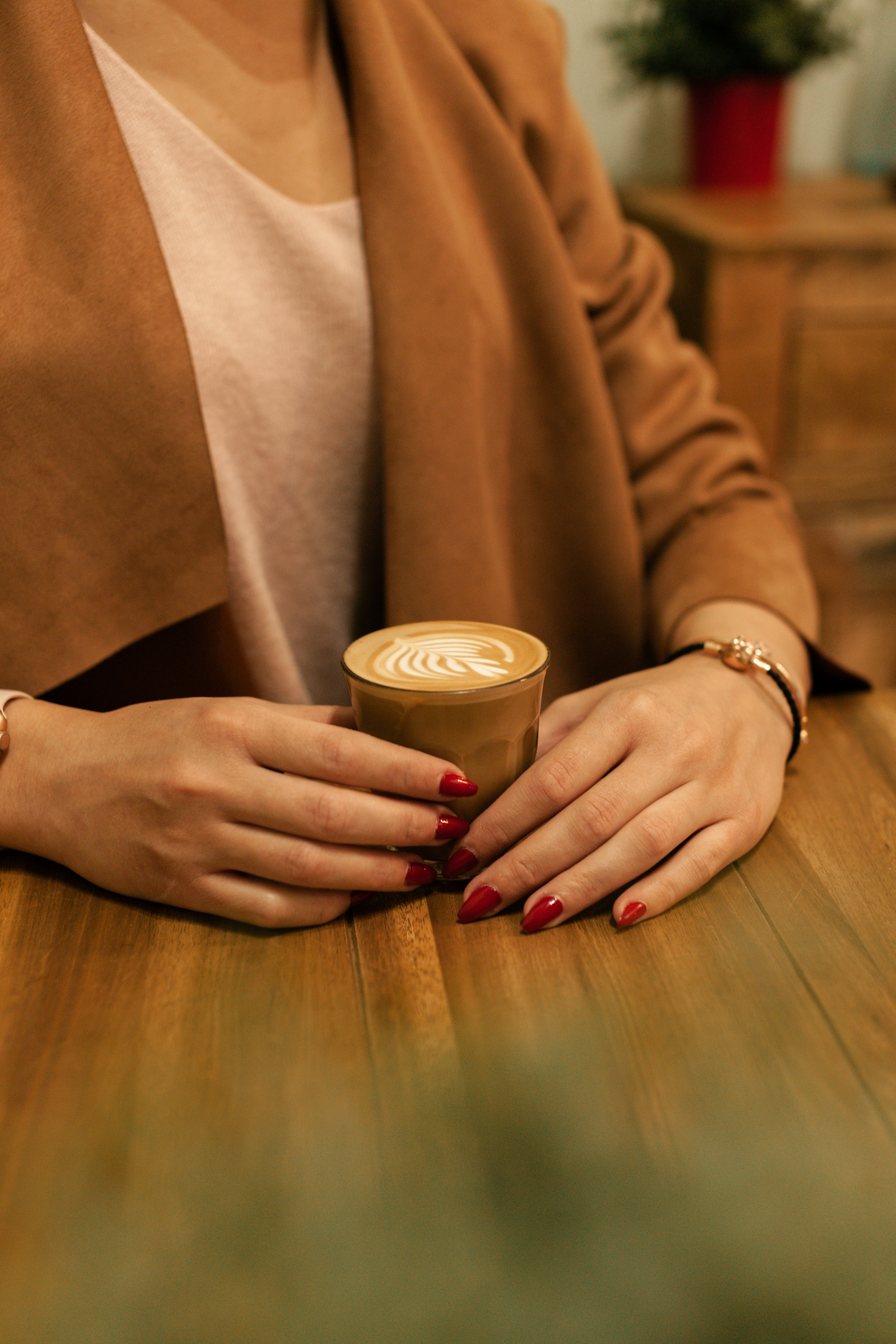 person in brown top holding cup