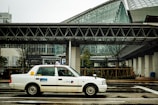 A taxi waiting outside a modern building.