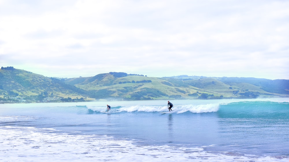 two person surfing on sea