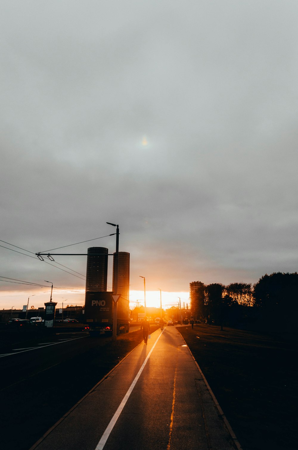 gray road near buildings under white clouds