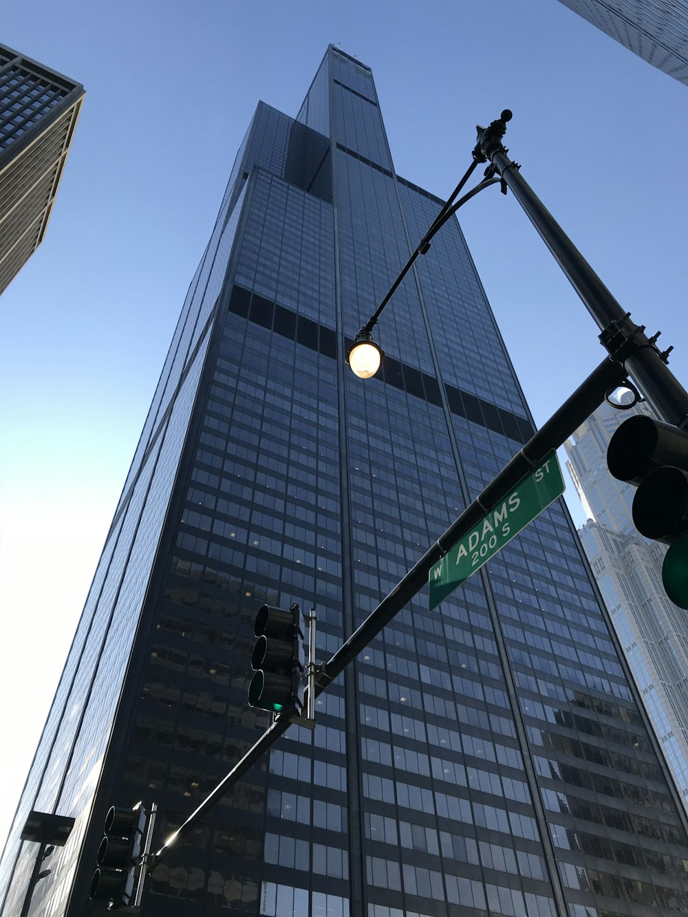 Photographie en contre-plongée d’un immeuble de verre bleu de grande hauteur