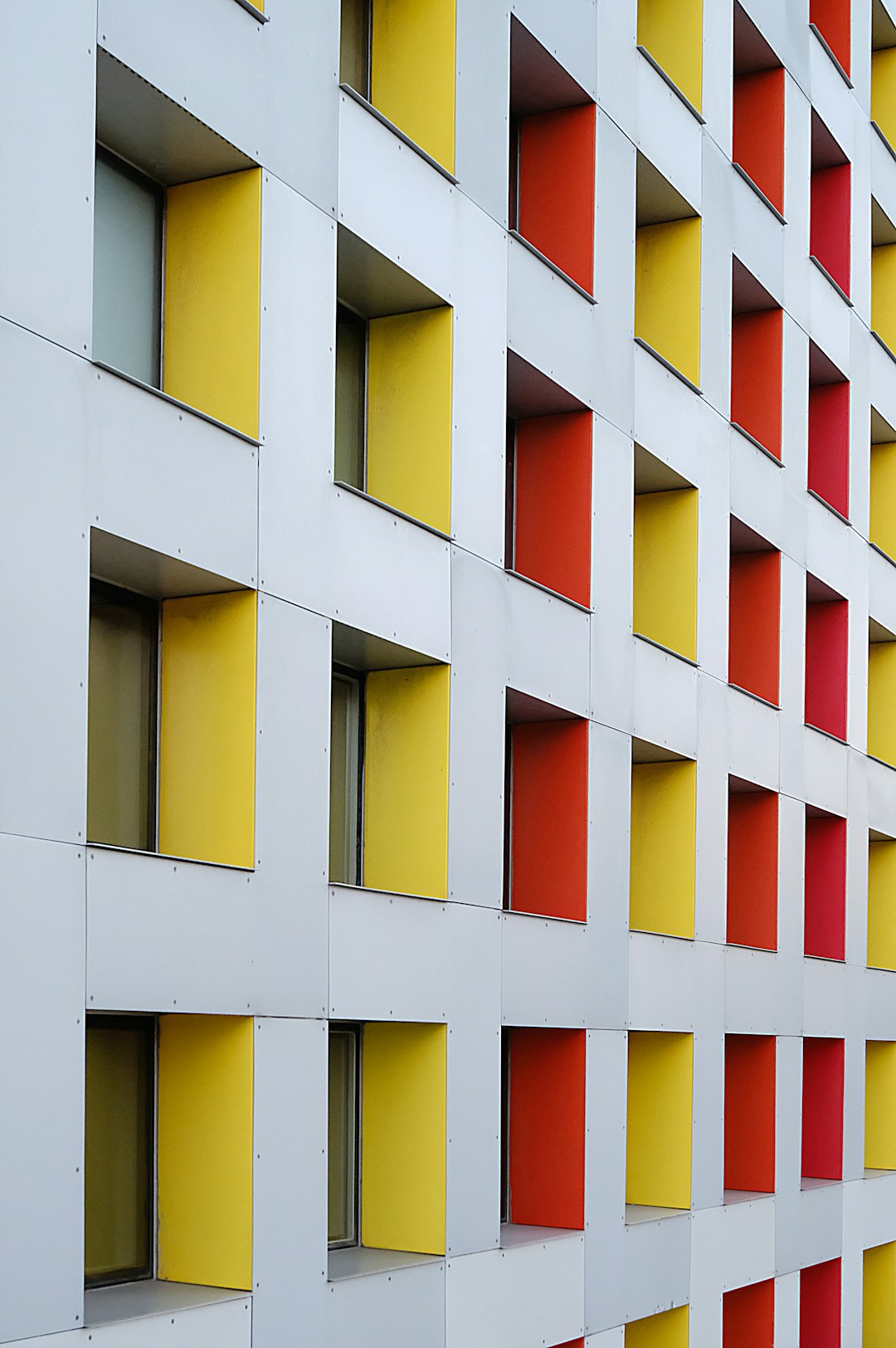 white, yellow, and red concrete multi-storey building