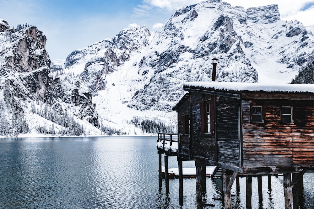 Braunes Stelzenhaus über Wasser in der Nähe von Gletscherbergen