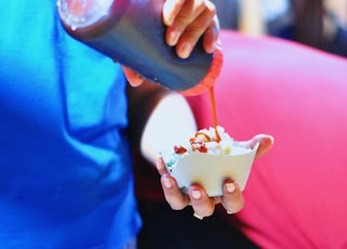selective focus photography of person pouring liquid into bowl