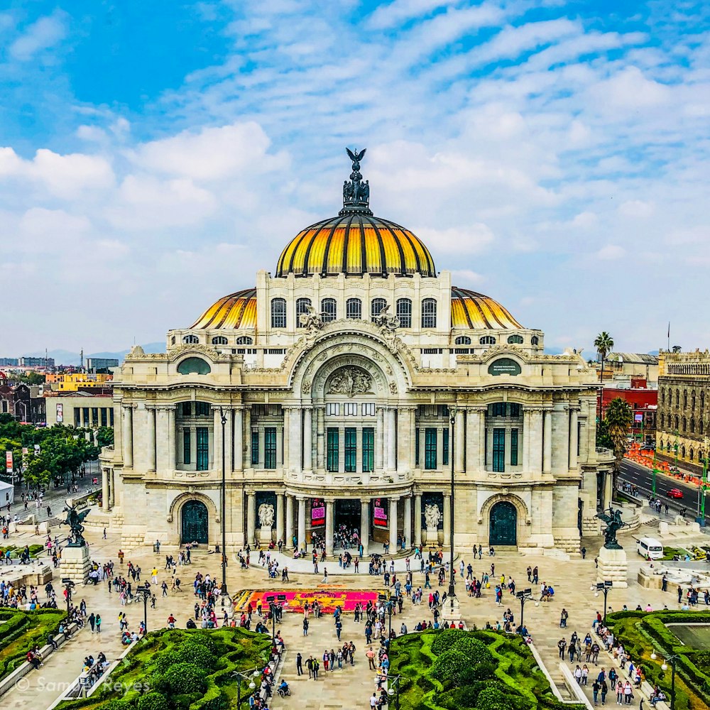 people walking near Palacio de Bellas Artes in Mexico City under white and blue sky during daytime