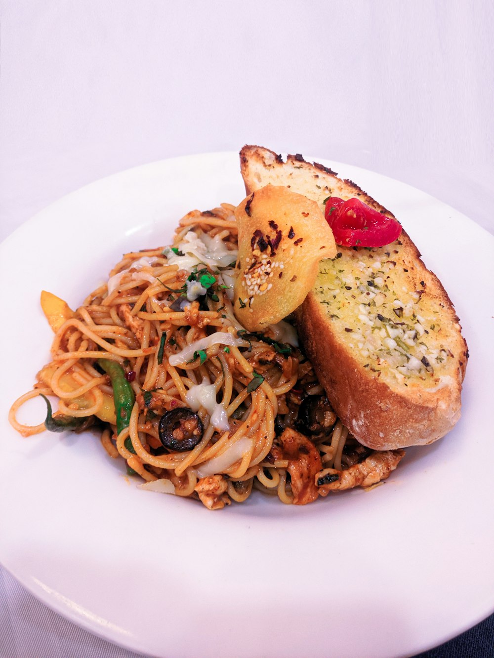 garlic bread and pasta on ceramic plate