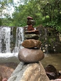 Stacked smooth stones beside a small water fountain creating tranquility.
