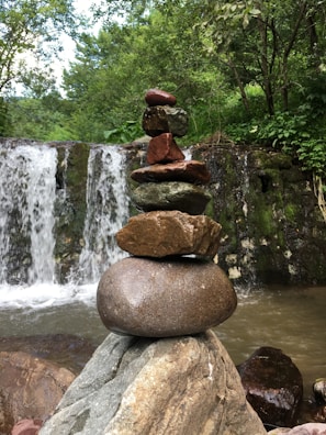Stacked smooth stones beside a small water fountain creating tranquility.