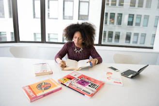 A close-up of a professional woman confidently reading an eBook on leadership development in a cozy office setting.
