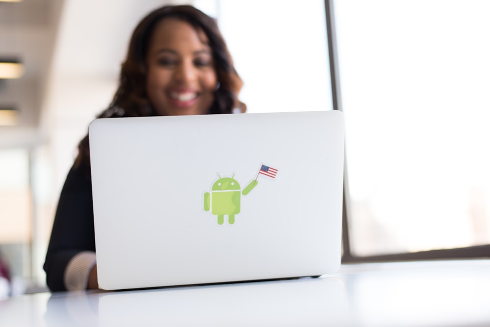 woman using laptop with android sticker