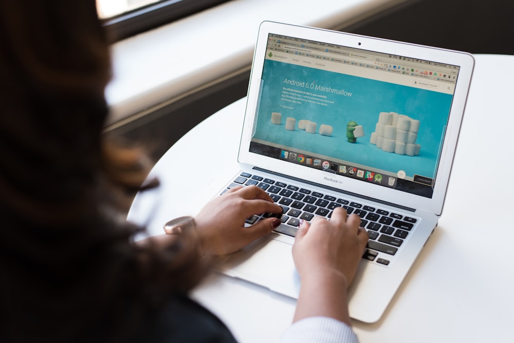 femme utilisant MacBook Air sur la table