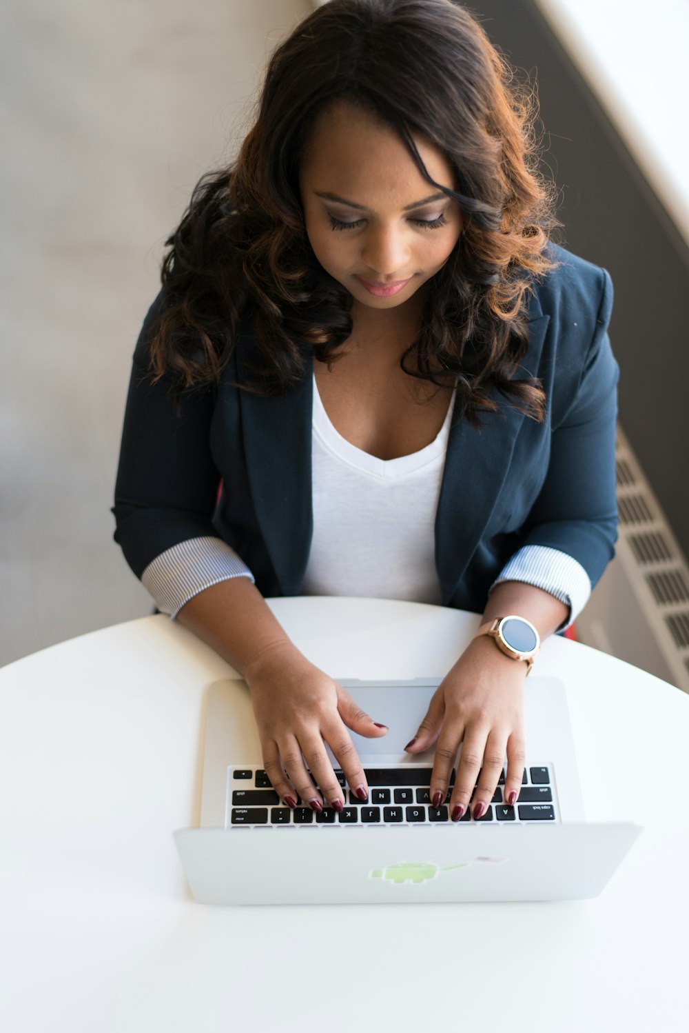 mulher que usa o portátil do MacBook na mesa