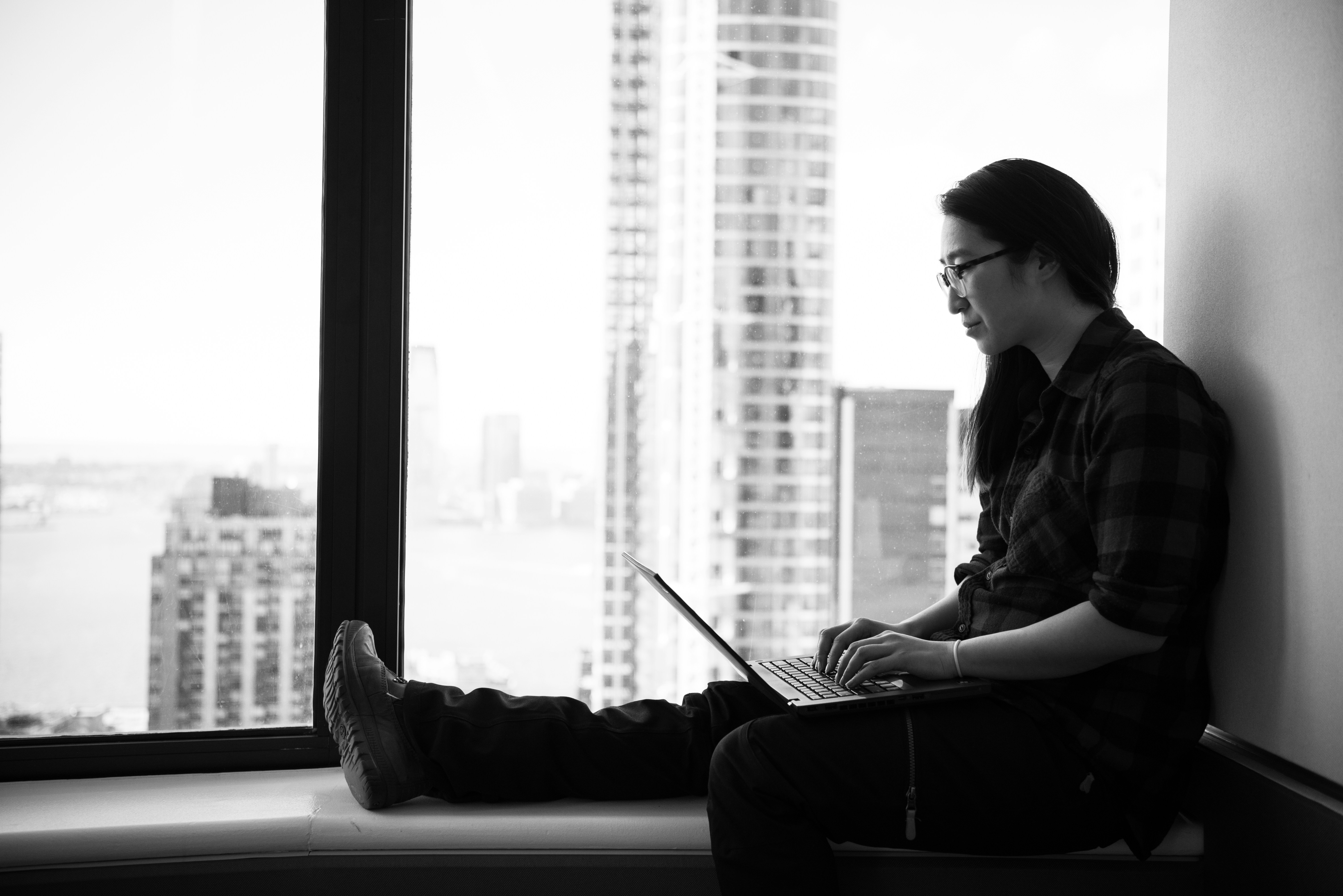 grayscale photography of woman facing laptop computer