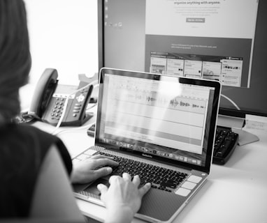 grayscale photo of person using laptop computer