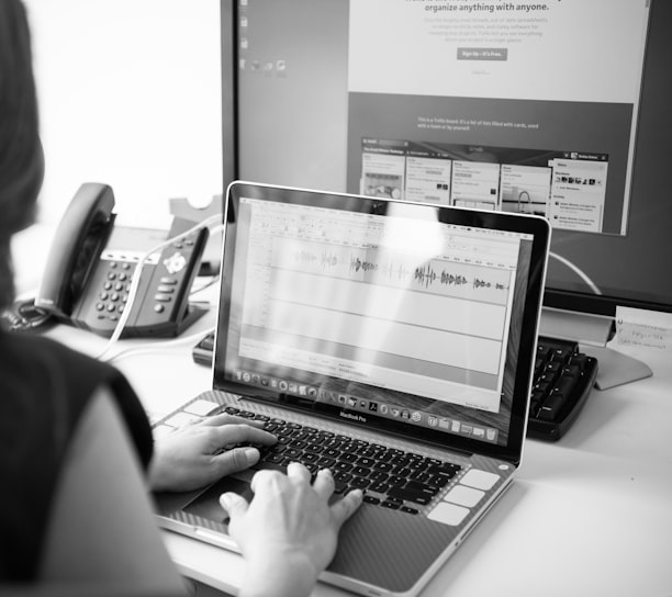 grayscale photo of person using laptop computer