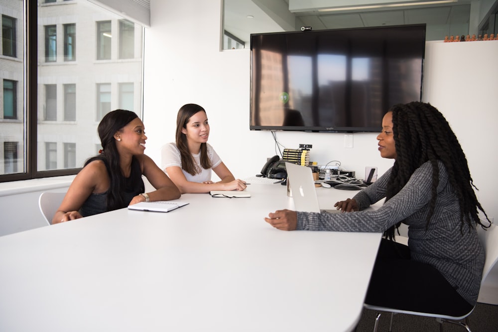 três mulheres sentadas à mesa