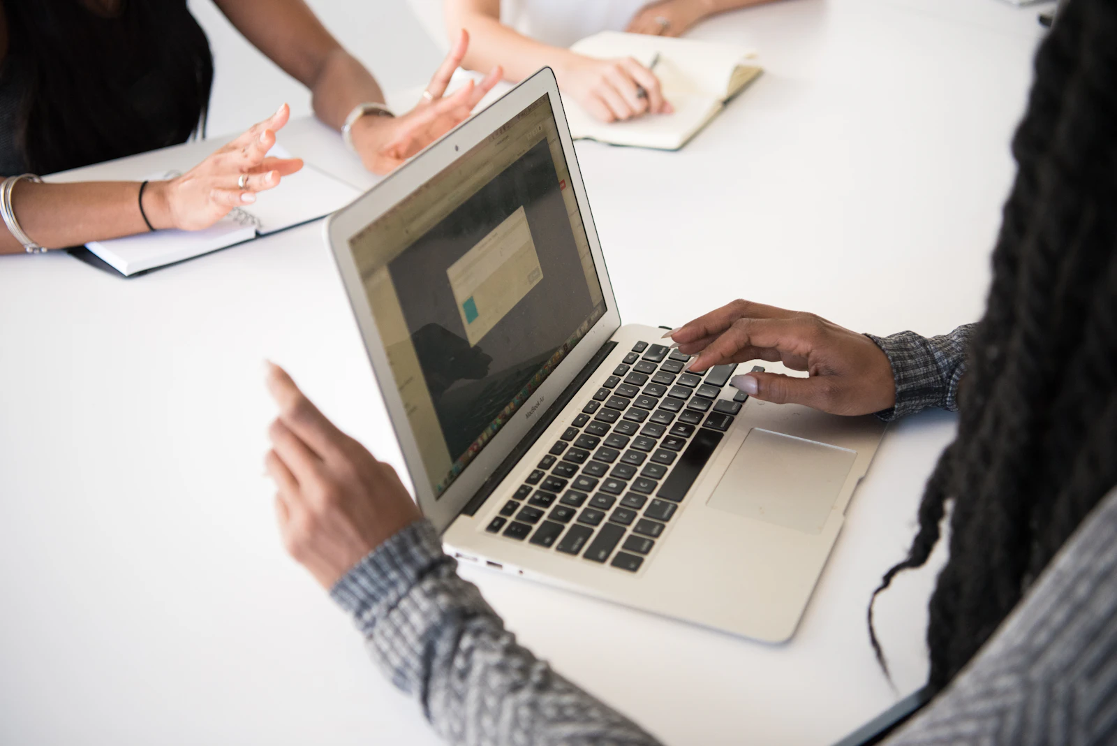A small team discussing work around a laptop