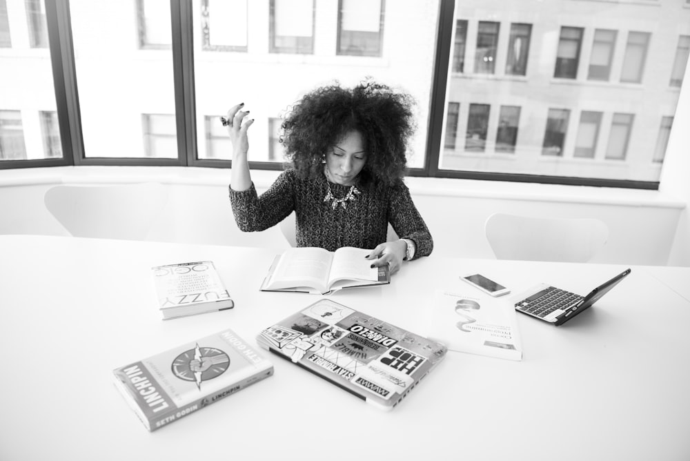 grayscale photography of woman reading book