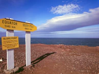 A panoramic shot of the equatorial line marker with travelers celebrating crossing it.