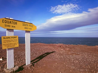 A panoramic shot of the equatorial line marker with travelers celebrating crossing it.
