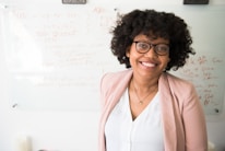 An instructor smiling warmly while explaining a concept on a digital whiteboard.