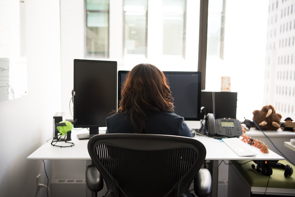 femme assise sur une chaise devant le bureau avec un bureau