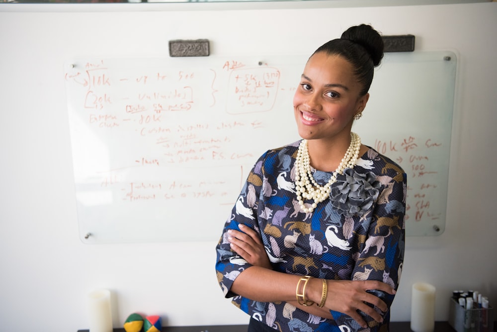 woman in blue and gray long-sleeved shirt wearing gold-colored necklace