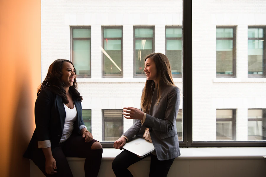 Two colleagues in conversation by a window