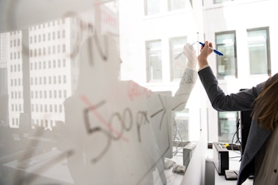 person writing on whiteboard