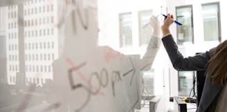 person writing on whiteboard