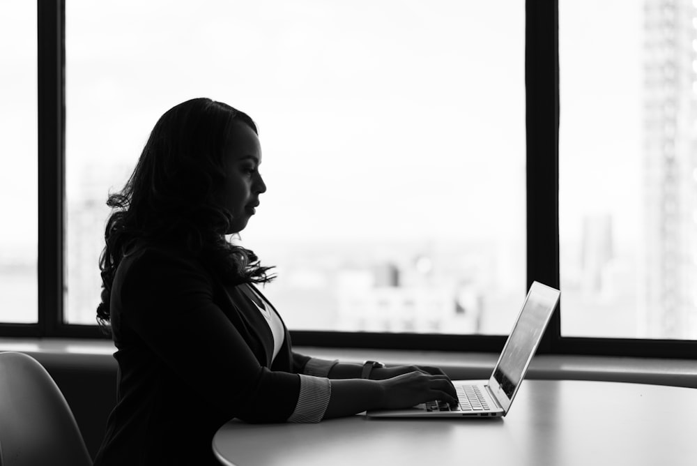 Mujer sentada y usando computadora portátil