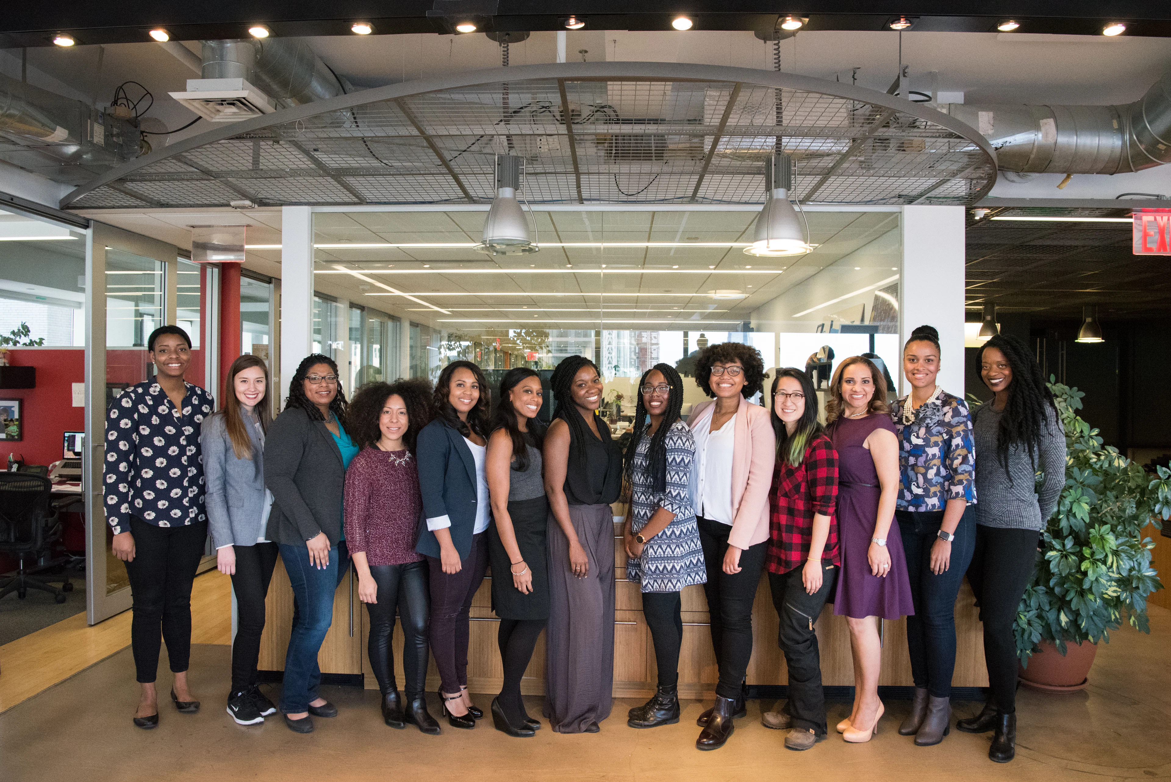 Professional women, several of them African, standing together in an office