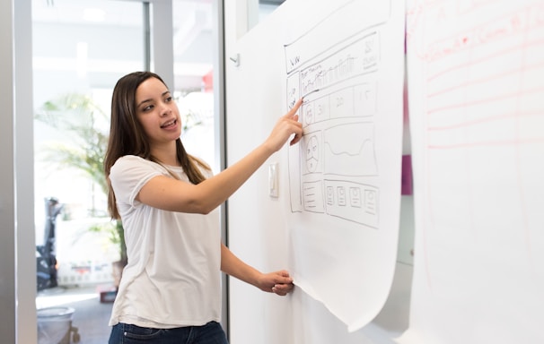 woman standing pointing paper on board