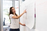 woman standing pointing paper on board