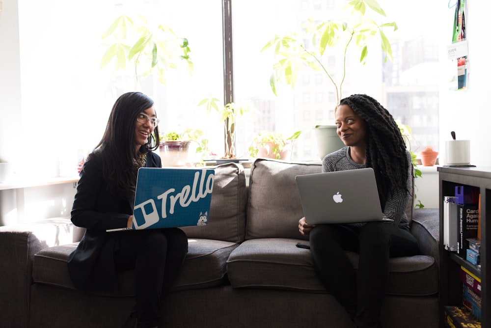 two women with laptop on laps