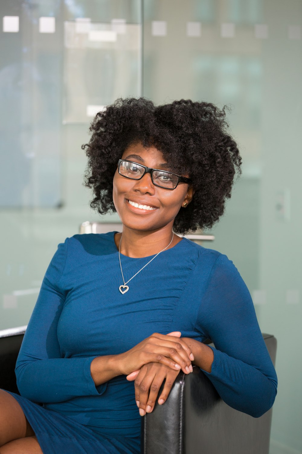 mujer sonriente sentada en silla negra