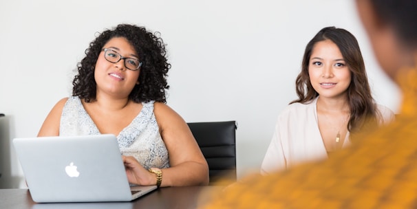 two women looking at person across the table