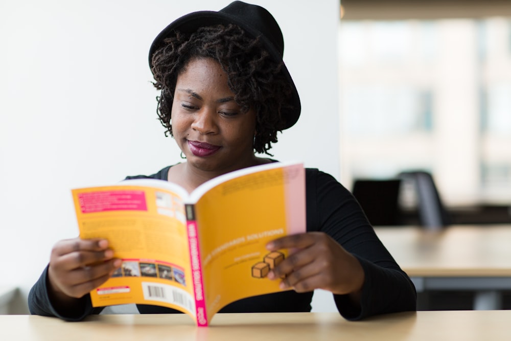 mujer sonriendo y leyendo libro