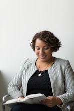 smiling woman sitting and reading book