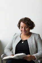 smiling woman sitting and reading book